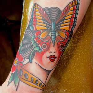 Capture the beauty of a butterfly, flower, and woman in this traditional style tattoo by Kat Freedman. Perfect for your forearm!
