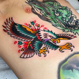 Experience timeless artistry in this chest tattoo by Nick Osbourn, featuring a majestic eagle clutching an arrow in traditional illustrative style.