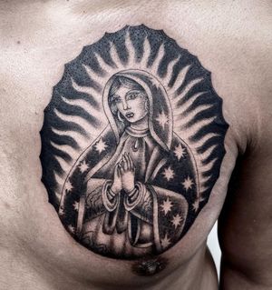 Blackwork tattoo featuring a stunning woman with star earrings and a mystical Mary motif, by Sasha Ignarski.