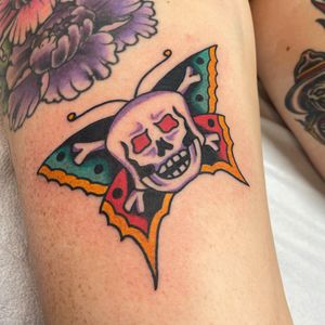 Get a unique illustrative traditional tattoo featuring a combination of a butterfly and a skull, done by the talented artist Nick Osbourn.
