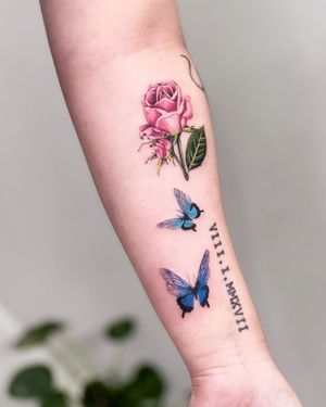 Beautiful illustrative tattoo by Juliany Braga showcasing a delicate butterfly and elegant flower design on the forearm.