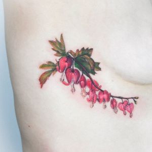 Get a stunning neo-traditional rib tattoo with vibrant flowers and fruits, inked by Juliany Braga.