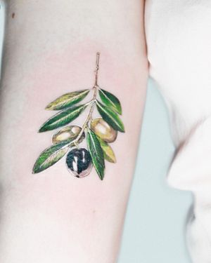 Vibrant illustrative tattoo of fruit and leaf design on upper arm by Juliany Braga. Perfect for nature lovers!