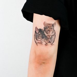 Capture the essence of the rat with this detailed and lifelike tattoo on your upper arm by tattoo artist Juliany Braga.