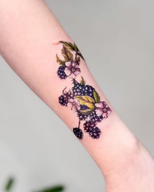 Beautiful forearm tattoo by Juliany Braga featuring a mix of grapes and flowers in illustrative style.