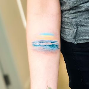Beautiful illustrative forearm tattoo featuring a stunning sea motif, created by Juliany Braga.