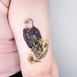 Experience the beauty of nature with this stunning realism and illustrative style tattoo by Juliany Braga on your upper arm.