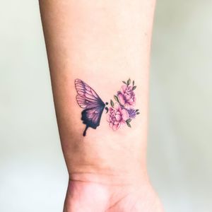 Beautiful illustrative tattoo featuring a butterfly and flower design, done by the talented Juliany Braga.