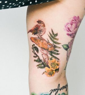 Vibrant neo-traditional upper arm tattoo featuring a bird, tree, and mushroom, impeccably executed by Juliany Braga.
