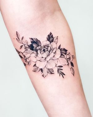 Get a stunning illustrative blackwork flower tattoo on your forearm by artist Juliany Braga.