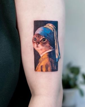 A stunning cat tattoo by Juliany Braga, beautifully illustrated on the upper arm for a timeless and unique look.