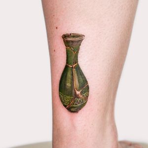 Get inked with a stunning illustrative vase design by Juliany Braga on your lower leg. This unique tattoo is sure to make a statement.