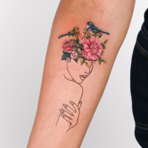 Vibrant neo-traditional style tattoo featuring a beautiful woman, bird, and flower by Juliany Braga. A stunning and intricate design for your forearm.