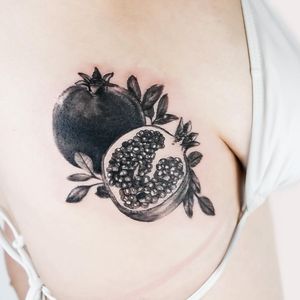Juliany Braga creates a stunning blackwork tattoo featuring a detailed pomegranate design on the ribs.