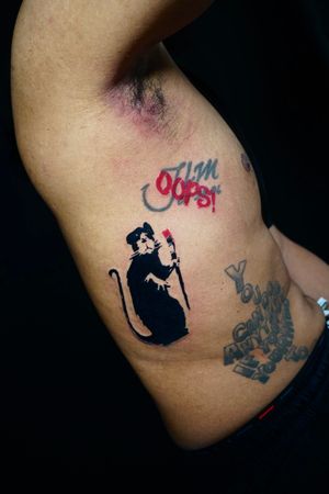 Unique illustrative tattoo by Miss Vampira featuring a stylized rat, brushstroke detail, and meaningful quote.