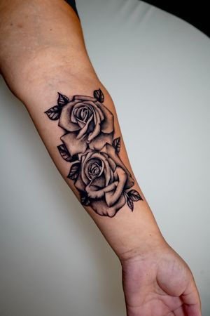 Elegant and bold blackwork flower design on forearm by the talented Miss Vampira. Perfect for those looking for a unique and illustrative tattoo.