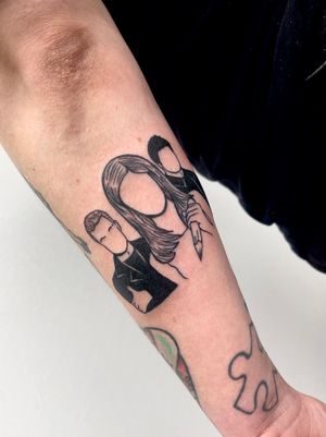 Blackwork forearm tattoo featuring a woman and man with a pencil motif, created by Miss Vampira