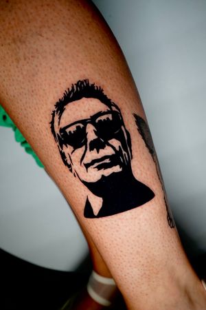 Unique blackwork forearm tattoo featuring a man wearing glasses, designed by Miss Vampira.
