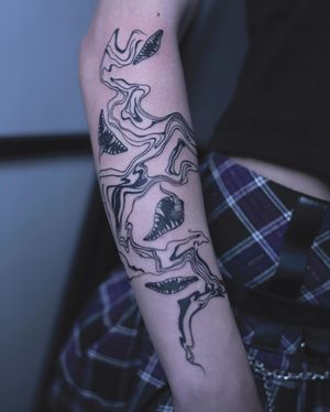 Explore the detailed pattern and mouth motif in this striking blackwork tattoo on the forearm. Created by the talented artist Greed.