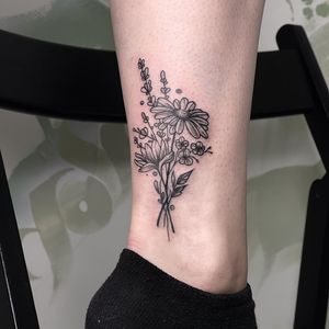 Get a stunning blackwork illustrative flower sprig tattoo on your lower leg by the talented Emiliia Kuzmina. Perfect for nature lovers.
