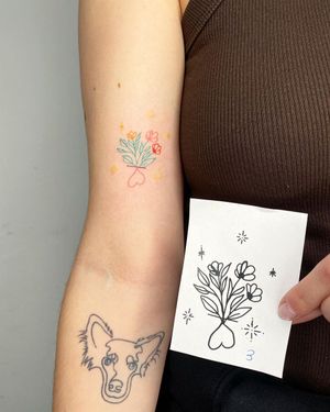A beautiful upper arm tattoo featuring a detailed illustrative design of a flower and heart, created by the talented artists Silber and Sofie.