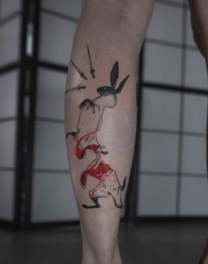 Illustrative lower leg tattoo featuring a stylized rabbit surrounded by a unique pattern and blood splatter, created by the talented artist Greed.