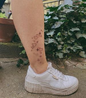 Illustrative tattoo on lower leg by Silber/Sofie, featuring a delicate star and heart motif.