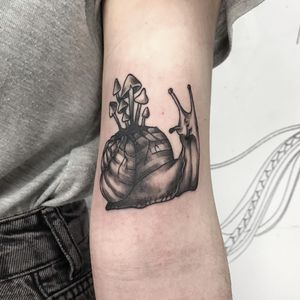 Illustrative design by Emiliia Kuzmina, perfect for upper arm placement. Unique snail and mushroom motif in bold blackwork style.