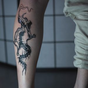 Get a bold and intricate blackwork tattoo on your lower leg featuring a unique skeleton pattern design by Greed.