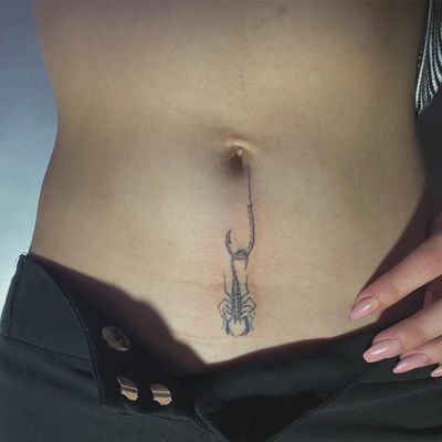 Adorn your stomach with a detailed and delicate scorpion and hook design, expertly executed by tattoo artist Amour.x.