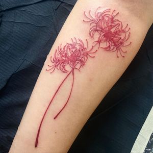 A beautiful flower tattoo on the forearm, skillfully done in an illustrative style by the talented artist Greed.
