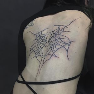 Experience the mesmerizing blend of surrealism and illustrative blackwork in this intricate back tattoo by Amour.x.