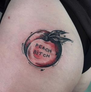 A unique tattoo featuring an apple and a meaningful quote, beautifully executed in lettering and illustrative style on the upper leg by Emiliia Kuzmina.