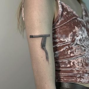 Unique blackwork upper arm tattoo by Amour.x featuring a fork and cigarette design.