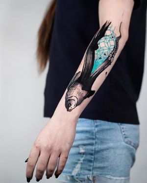 Bold blackwork design of a fish and intricate pattern on forearm created by talented artist Joza.