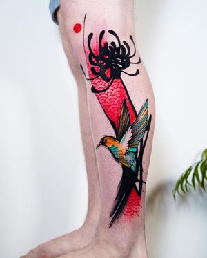 Beautiful blackwork with watercolor accents by tattoo artist Joza, featuring a hummingbird, flower, and intricate pattern.
