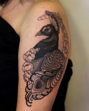 Exquisite neo traditional tattoo design of a vibrant peacock and heart by artist Edyta, perfect for upper arm placement.