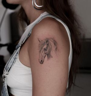 Experience the artistry of Oscar Jesus with this bold and detailed horse tattoo, perfect for your upper arm.