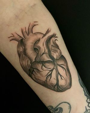 Celebrate your love with a elegant black and gray fine line tree and heart tattoo by Edyta on your forearm.