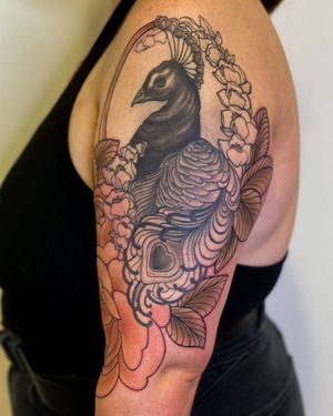 Edyta's beautiful neo-traditional tattoo design features a vibrant peacock and intricate flower, perfect for the upper arm placement.