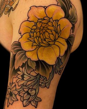 Brighten up your upper arm with a neo-traditional sunflower tattoo by Edyta. This bold and colorful design will stand out beautifully on your skin.