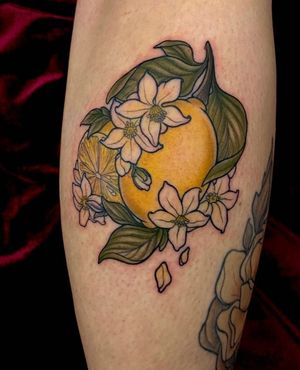 Beautiful lower leg tattoo featuring a vibrant neo-traditional design of flowers and lemons by artist Edyta.