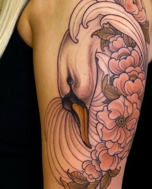 Beautiful neo-traditional tattoo on upper arm featuring a intricate design of a swan and flower by the talented artist Edyta.