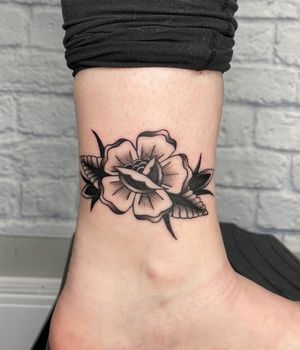 Beautiful blackwork flower tattoo by Jenna Jeep, perfect for ankle placement.
