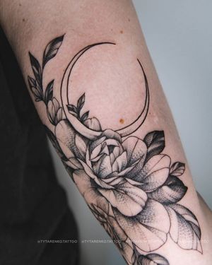 Experience the enchanting beauty of a blackwork moon and flower tattoo on your upper arm by Kateryna Tytarenko.