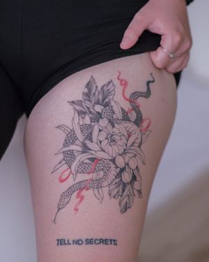 Unique blackwork and illustrative design by Sasha Sunshine on upper leg featuring a snake entwined with a flower.