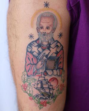 A stunning tattoo featuring a flower, ship, cross, saint, bible, man, and book. Intricately designed with illustrative style.