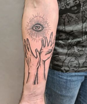 Liza Vettaa's blackwork forearm tattoo featuring a captivating eye and hand design, perfect for a bold and illustrative look.