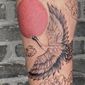 Elegant and mystical lower leg tattoo featuring a sun, bird, heron, and wings in Palena's illustrative blackwork style.
