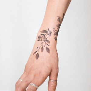 Unique blackwork leaf design on forearm by talented artist Yasmin Clara. Detailed and eye-catching.